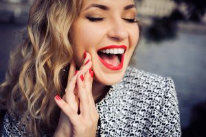 Woman with bright red lips laughing